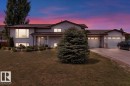 Split-level residence featuring a gray exterior, a two-car garage with individual doors, and a concrete driveway - 5506 53St, Mundare, AB 