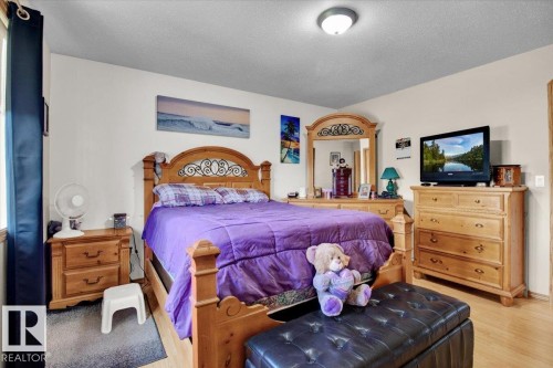 Bright interior space featuring a window with dark drapes, light-colored walls, and a ceiling-mounted light fixture - 5506 53St, Mundare, AB 