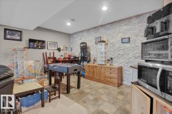 Recreation area featuring a stone accent wall, recessed lighting, and a blend of carpet and tile flooring - 
