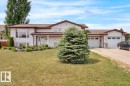 Split-level residence featuring light-colored siding and a brown shingle roof - 5506 53St, Mundare, AB 