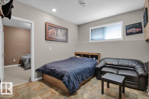 Room featuring neutral toned walls, recessed ceiling lighting, a window with blinds, and tile-finish flooring - 5506 53St, Mundare, AB 