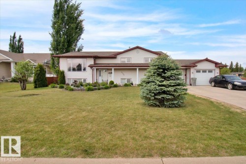 Split-level residence featuring white siding and a brown roof - 5506 53St, Mundare, AB 