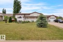 Split-level residence featuring white siding and a brown roof - 5506 53St, Mundare, AB 