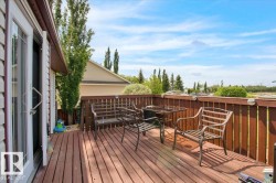 Spacious wood-plank deck featuring a wood railing with integrated lighting and dual glass-paned doors - 