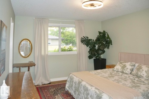 Bedroom featuring a single window with white trim, light-colored walls, and a ceiling-mounted light fixture - 25 8930 99 Avenue, Fort Saskatchewan, AB 