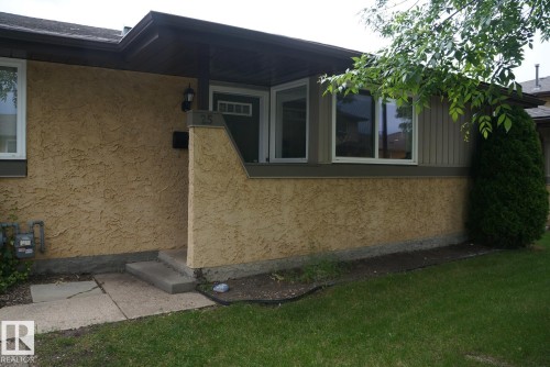 Front exterior featuring textured stucco siding and contrasting horizontal paneling - 25 8930 99 Avenue, Fort Saskatchewan, AB 