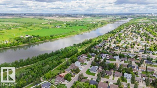Aerial perspective showcasing a residential area bordered by a river and green spaces - 25 8930 99 Avenue, Fort Saskatchewan, AB 