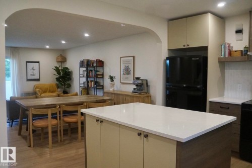 Kitchen island featuring a white countertop and two-tone cabinetry - 25 8930 99 Avenue, Fort Saskatchewan, AB 