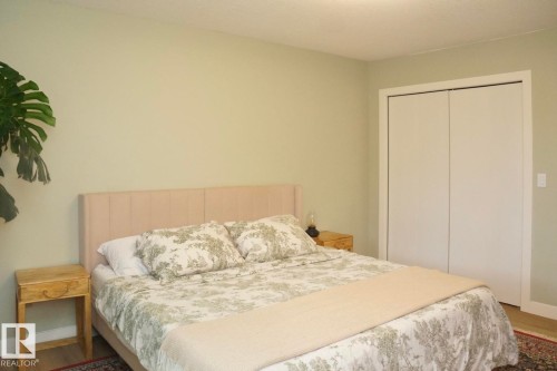 Bedroom featuring light-toned walls, wood-finish flooring, and white trim - 25 8930 99 Avenue, Fort Saskatchewan, AB 