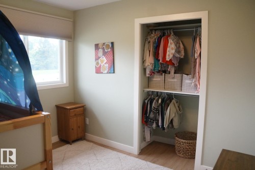 Recessed closet featuring two levels of hanging rods and an upper shelf - 25 8930 99 Avenue, Fort Saskatchewan, AB 