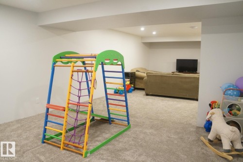 Expansive carpeted room featuring recessed lighting and a neutral color palette - 25 8930 99 Avenue, Fort Saskatchewan, AB 