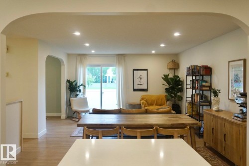 Open-concept living space featuring wood-finish flooring, recessed lighting, and a sliding glass door - 25 8930 99 Avenue, Fort Saskatchewan, AB 