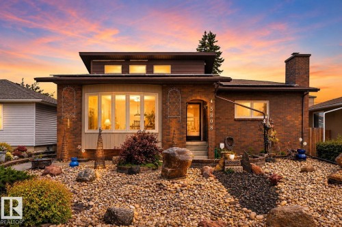 Brick exterior featuring a bay window, upper-level transom windows, and a prominent brick chimney - 5808 Austin O'Brien Road, Edmonton, AB 