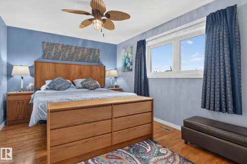 Primary Bedroom featuring wood-finish flooring, a ceiling fan with integrated lighting, and a double window providing natural light - 5808 Austin O'Brien Road, Edmonton, AB 