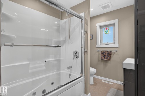 Jetted bathtub with clear glass sliding doors and polished chrome fixtures - 5808 Austin O'Brien Road, Edmonton, AB 