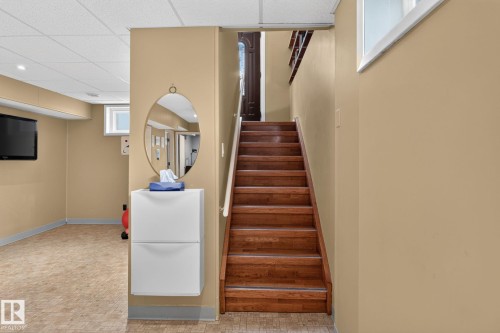 Staircase with wood-finish treads and risers, leading to a visible upper-level doorway - 5808 Austin O'Brien Road, Edmonton, AB 