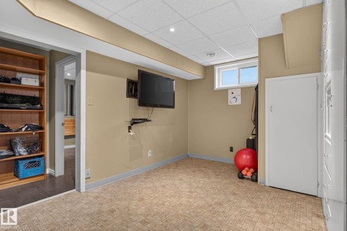 Lower level space featuring light-colored flooring, neutral wall paint, and a drop ceiling - 5808 Austin O'Brien Road, Edmonton, AB 