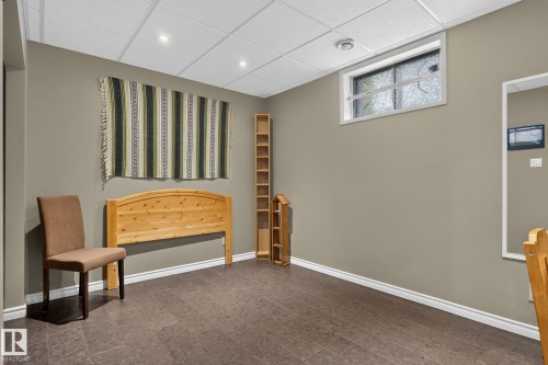 4th Bedroom  featuring recessed lighting, a drop ceiling, textured flooring, and a high window with opaque glass - 5808 Austin O'Brien Road, Edmonton, AB 