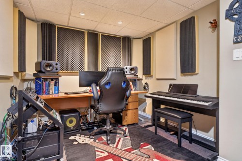 Dedicated room featuring acoustic wall paneling, a wood-finish desk, recessed lighting, drop ceiling, and dark wood-finish flooring - 5808 Austin O'Brien Road, Edmonton, AB 