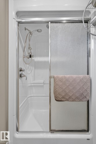 White fiberglass tub and shower combination with sliding textured glass doors - 5808 Austin O'Brien Road, Edmonton, AB 