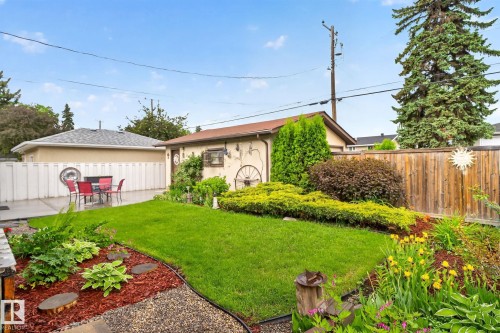 Expansive backyard featuring a central lawn area, concrete patio, and a separate detached structure - 5808 Austin O'Brien Road, Edmonton, AB 