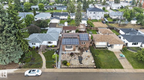 Modern facade featuring a prominent solar panel array, bay window, and a stone and rock front yard landscaping design - 5808 Austin O'Brien Road, Edmonton, AB 
