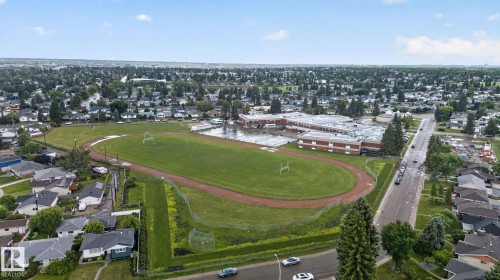Aerial perspective showcasing a residential area with extensive green spaces and mature tree coverage - 5808 Austin O'Brien Road, Edmonton, AB 