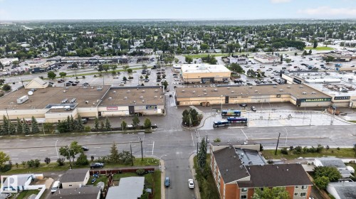 Urban landscape featuring diverse commercial buildings, expansive parking areas, and mature tree-lined streets - 5808 Austin O'Brien Road, Edmonton, AB 