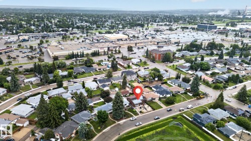 Aerial overview of a residential neighborhood with a prominent commercial retail center in the background - 5808 Austin O'Brien Road, Edmonton, AB 