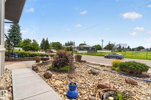 Front entry featuring a concrete walkway and extensive rock landscaping - 5808 Austin O'Brien Road, Edmonton, AB 