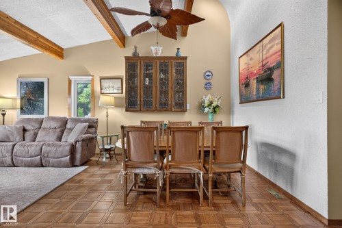Vaulted ceiling with exposed wood beams, wood-finish flooring, and a built-in display cabinet - 5808 Austin O'Brien Road, Edmonton, AB 