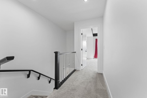 Upper-level hallway featuring light gray carpeting, crisp white walls, and recessed lighting - 3606 42 Avenue, Beaumont, AB 