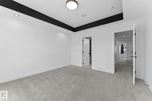 Spacious room with light gray carpet and white walls - 3606 42 Avenue, Beaumont, AB 