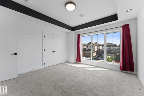 Spacious room featuring a multi-pane window, light gray carpeting, and white walls - 3606 42 Avenue, Beaumont, AB 