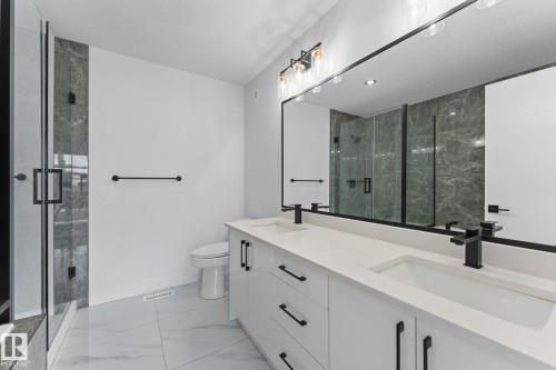 Modern bathroom featuring a dual vanity with white cabinetry and integrated sinks - 3606 42 Avenue, Beaumont, AB 