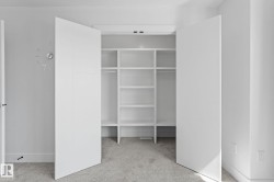 Built-in closet system featuring white shelving and hanging rods - 