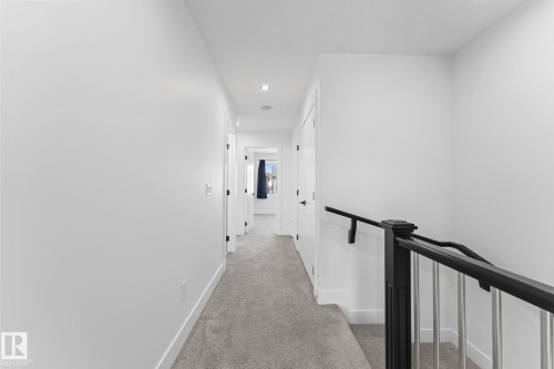 Carpeted hallway with white walls and trim - 3606 42 Avenue, Beaumont, AB 