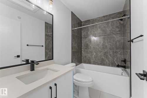 Bathroom featuring a white vanity with a light-toned countertop, an undermount sink, and a matte black faucet - 3606 42 Avenue, Beaumont, AB 