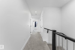 Carpeted hallway with white walls and trim - 