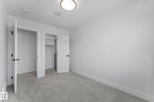 Room featuring light grey carpet flooring, white painted walls, and white baseboards - 3606 42 Avenue, Beaumont, AB 