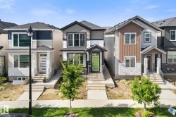 Modern home with a striking lime green front door, featuring a covered entry, dark trim windows, and mixed siding with stone accents - 