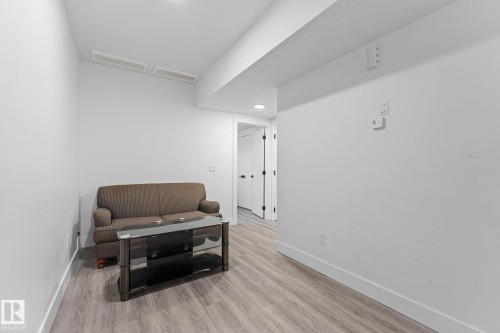 Spacious room with light wood-finish flooring, white walls, and recessed lighting - 3606 42 Avenue, Beaumont, AB 