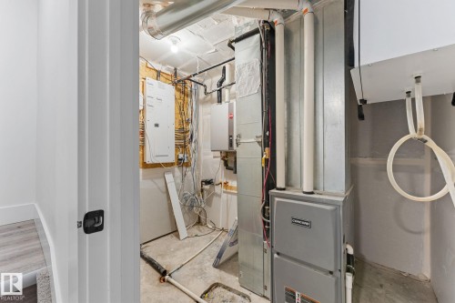 Utility room featuring an electrical panel, exposed ductwork, furnace, and water heater - 3606 42 Avenue, Beaumont, AB 