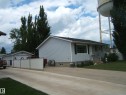 Light gray siding exterior with a black shingle roof - 4606 51 Avenue, Two Hills, AB 