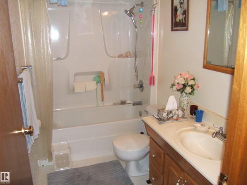 Bathroom featuring a white tub and shower combination with a single-handle faucet - 4606 51 Avenue, Two Hills, AB 