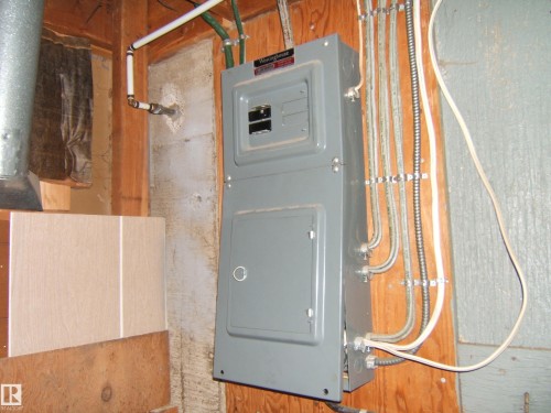 Electrical service panel with various conduits and wiring - 4606 51 Avenue, Two Hills, AB 
