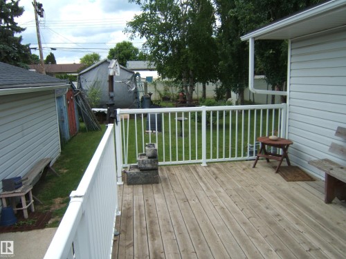 Spacious wood-plank deck with white railing - 4606 51 Avenue, Two Hills, AB 