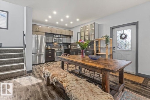 Modern kitchen featuring stainless steel appliances, upper cabinetry with glass inserts, a tile backsplash, and recessed lighting - 3 7210 96 Street, Edmonton, AB - Indoor