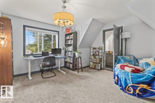 Attic room featuring a large window, sloped ceilings, and light gray carpeted flooring - 3 7210 96 Street, Edmonton, AB - Indoor Photo Showing Office