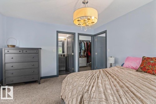 Carpeted bedroom with light blue walls and a crystal-accented ceiling light fixture - 3 7210 96 Street, Edmonton, AB - Indoor Photo Showing Bedroom